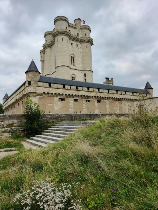 a large castle on top of a grassy hill