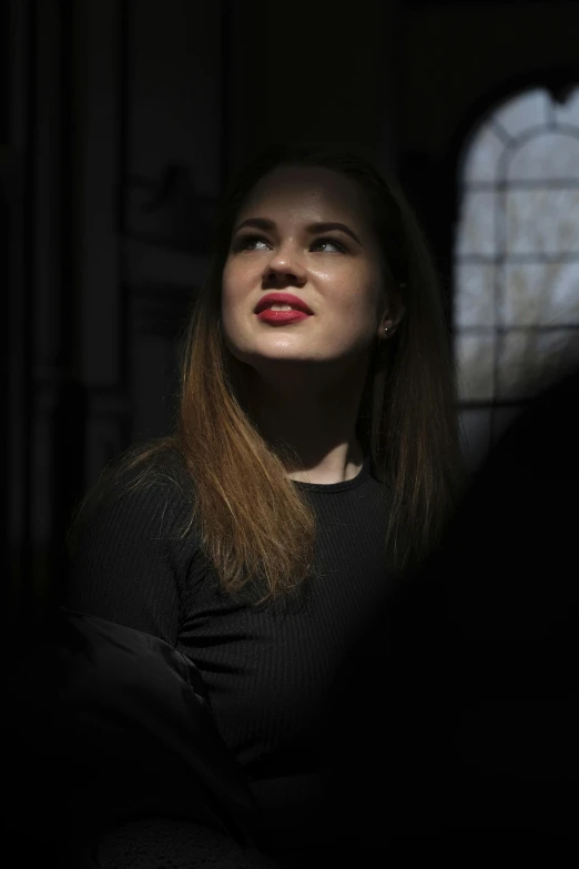 woman in black shirt looking out from behind her