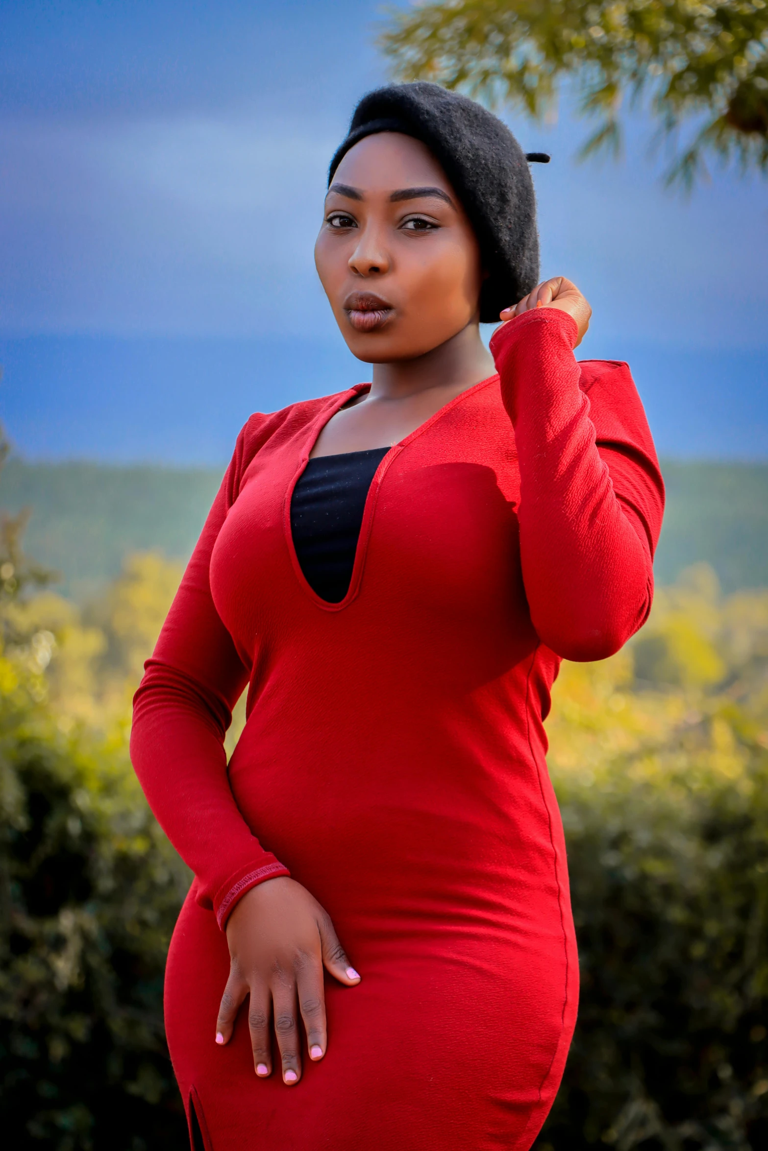 a woman poses for a picture in a red dress