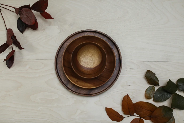 wooden bowl on a white table next to leaves