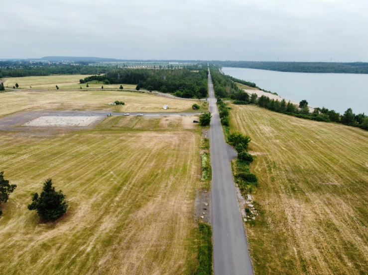 an aerial view of a two lane road through a field