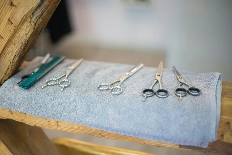 several pairs of scissors and needle tip pliers are placed on a towel