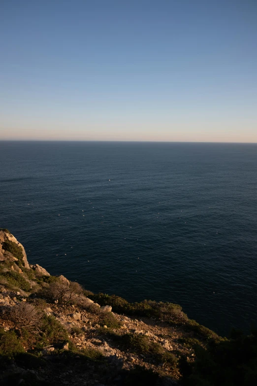 the ocean has a cliff in front of it