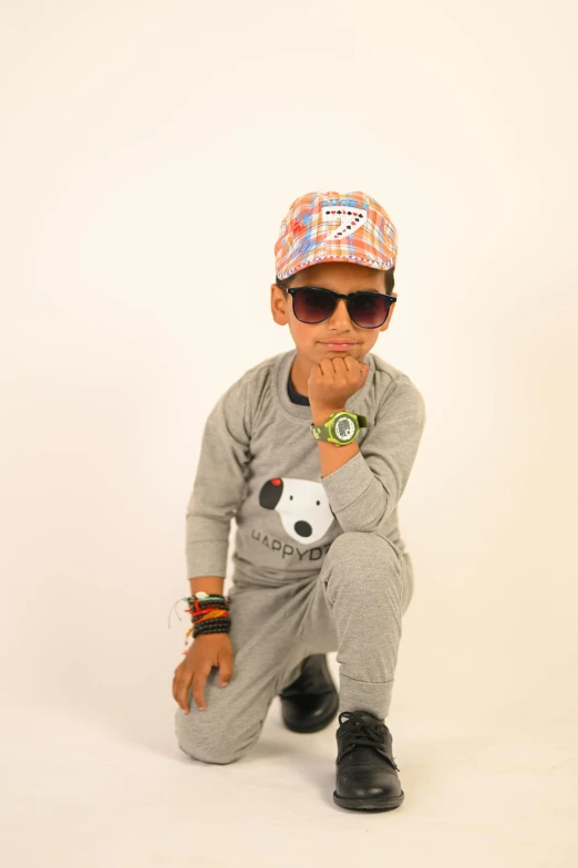 a small child poses with sunglasses and headphones