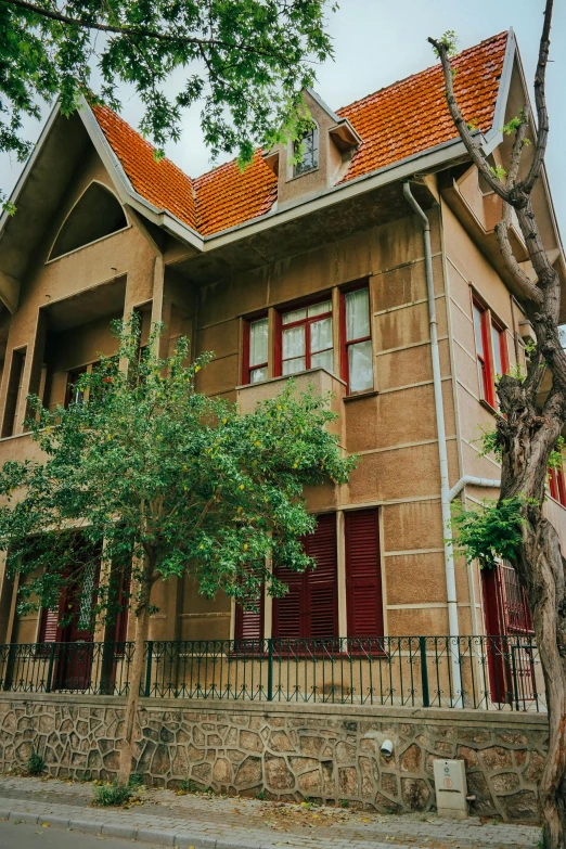 a large house with a fence and trees on the side