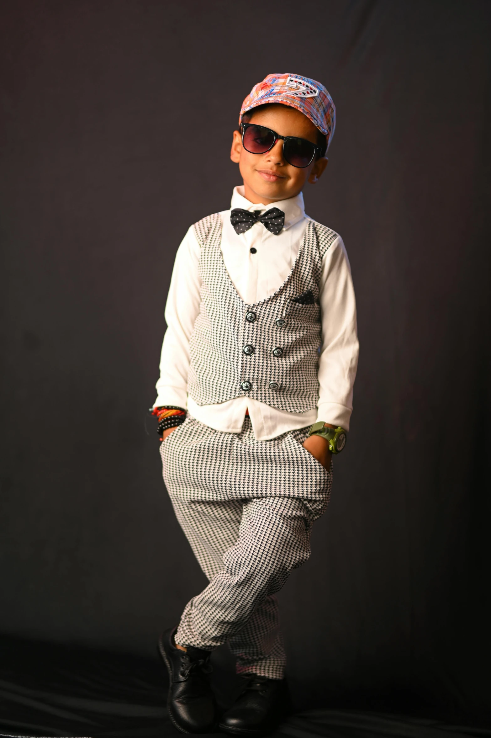 a boy in a tuxedo poses for a picture