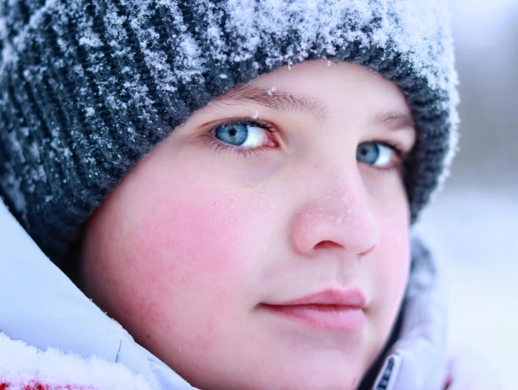 a close up of a young person wearing a hat