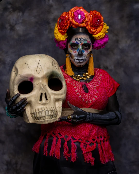 a woman in mexican makeup holds a skull