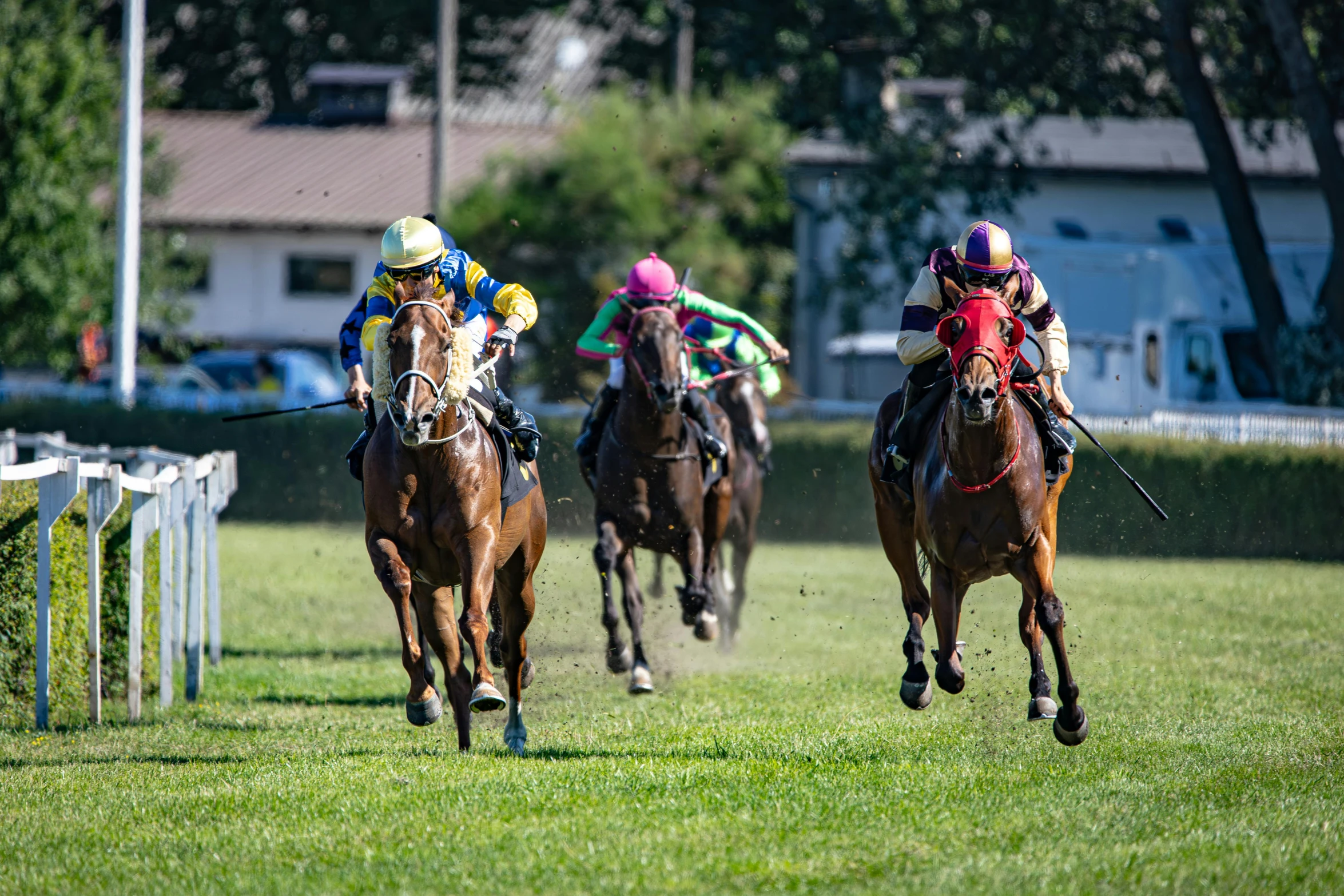 three horse and jockey racing around the track