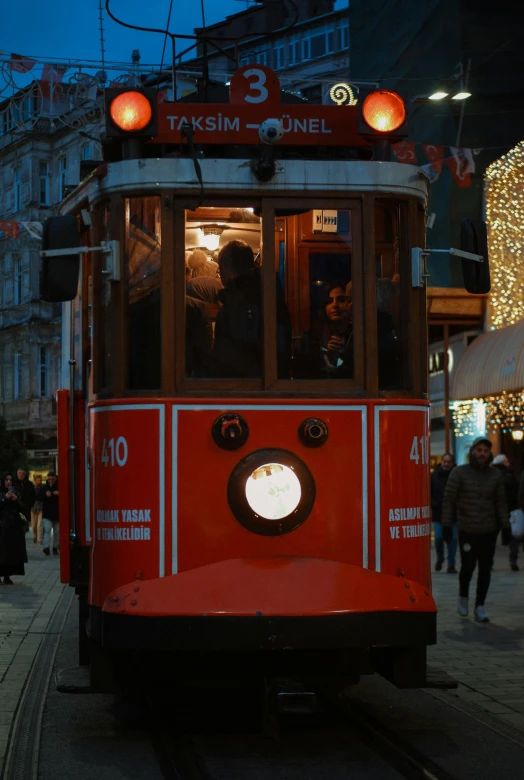 a trolley car on the street with many people around