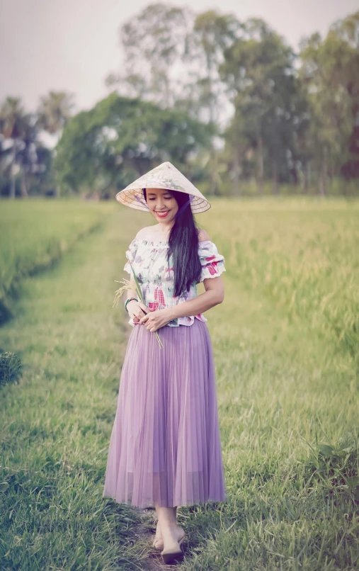 a woman wearing a purple dress and a hat