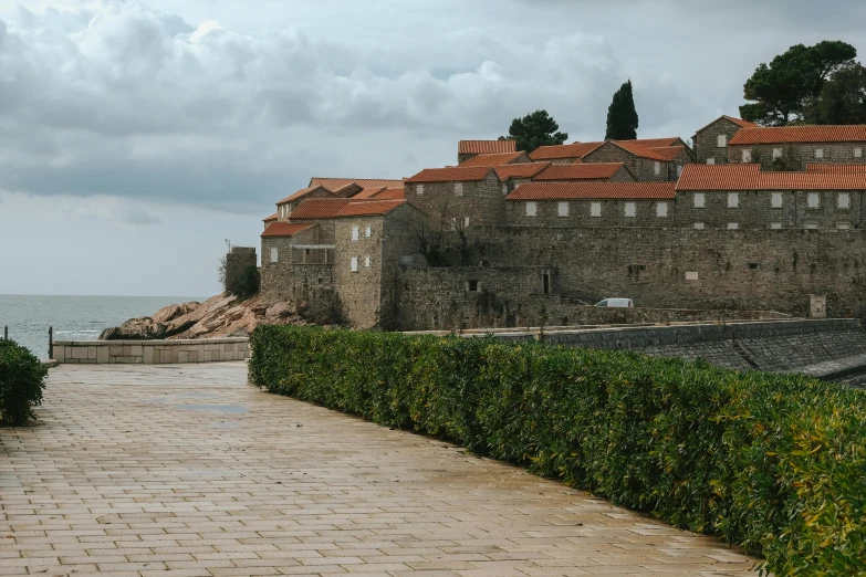 a road leads to an old wall and some houses