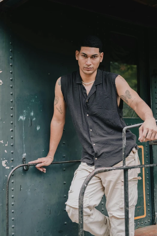 man in hat leaning against a train platform