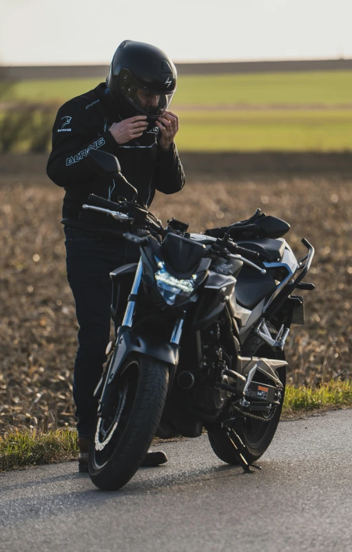 a person that is on a motorcycle that is standing near the street