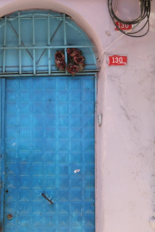 a pair of brown sandals sitting on the bottom of a blue door