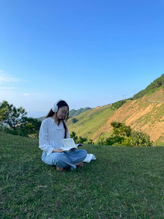 woman sitting on grass with laptop in front of her