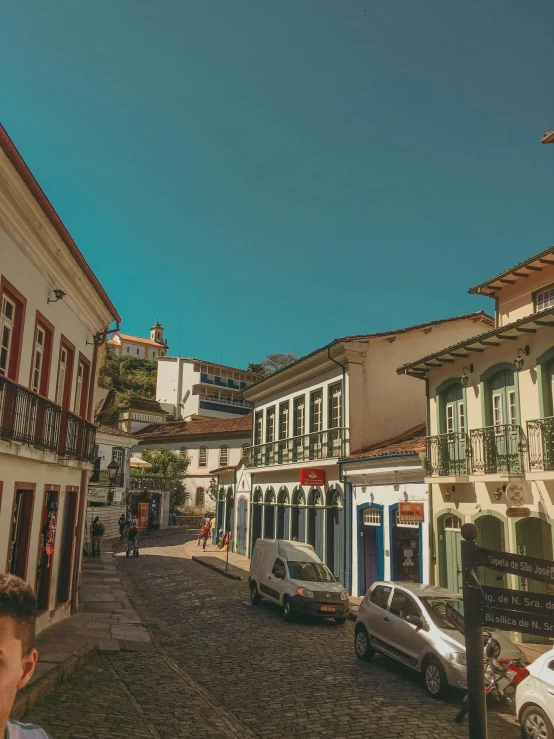 a row of multi colored building on a cobble stone road