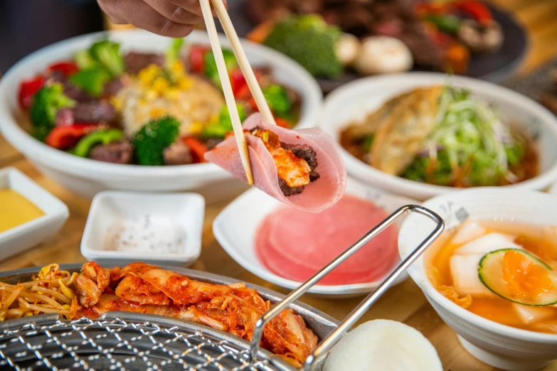 a variety of different types of food with chopsticks