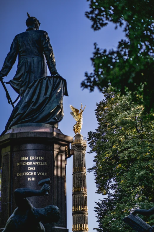 a statue is sitting next to a statue on a pillar