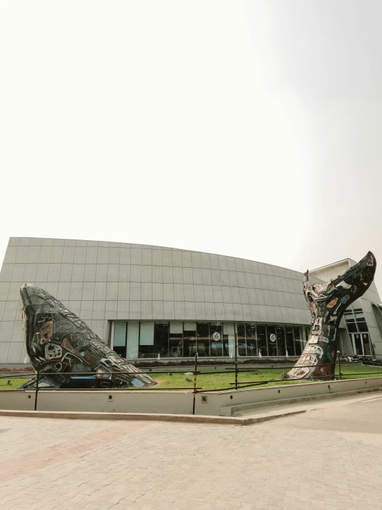 there is a large building that has a large giant sculpture of two dinosaurs in front of it