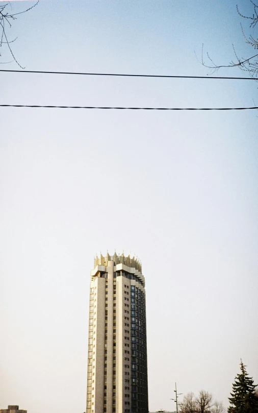 a high rise building in the middle of a city with power lines overhead