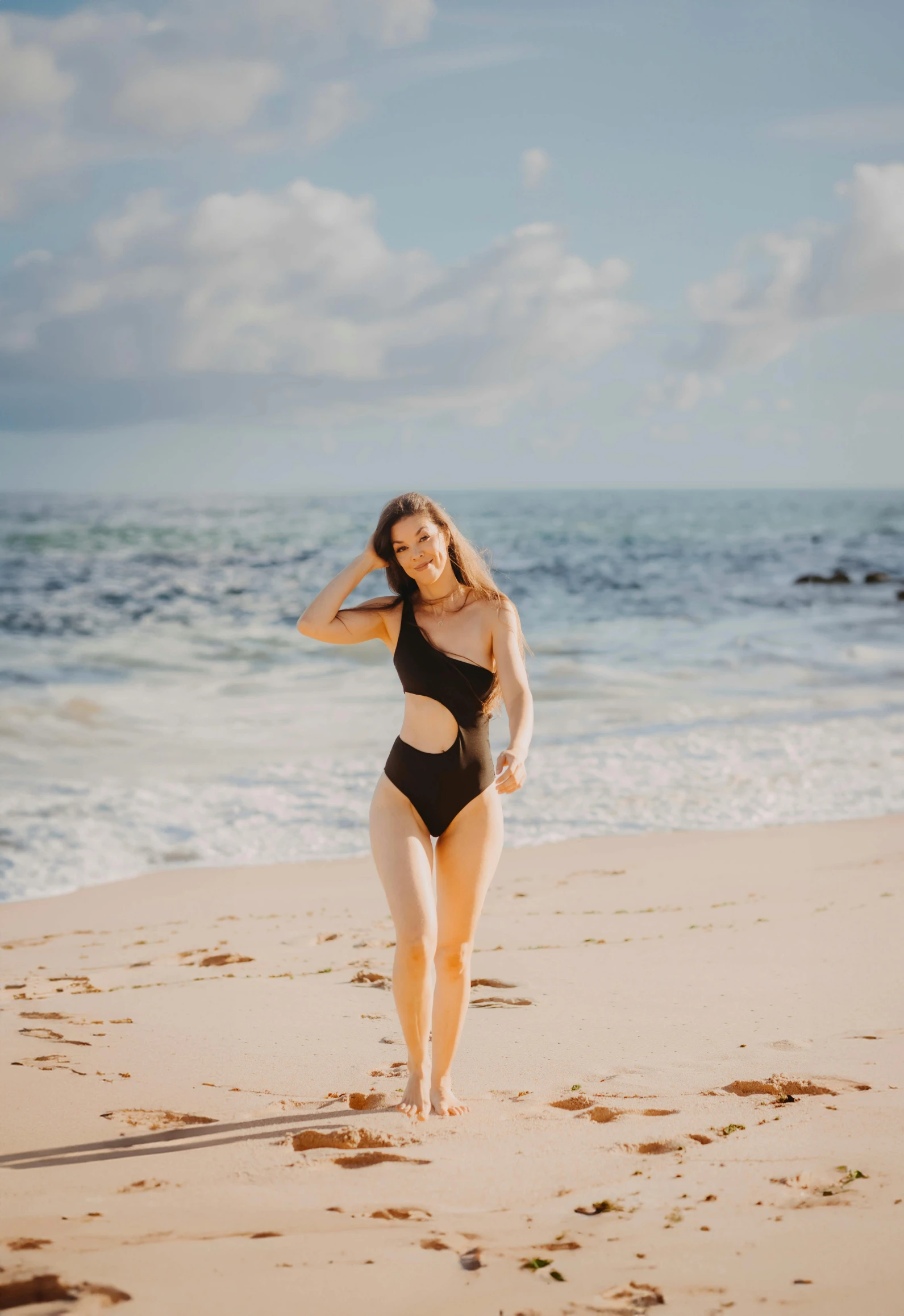 an older woman walking in her swimsuit on the beach