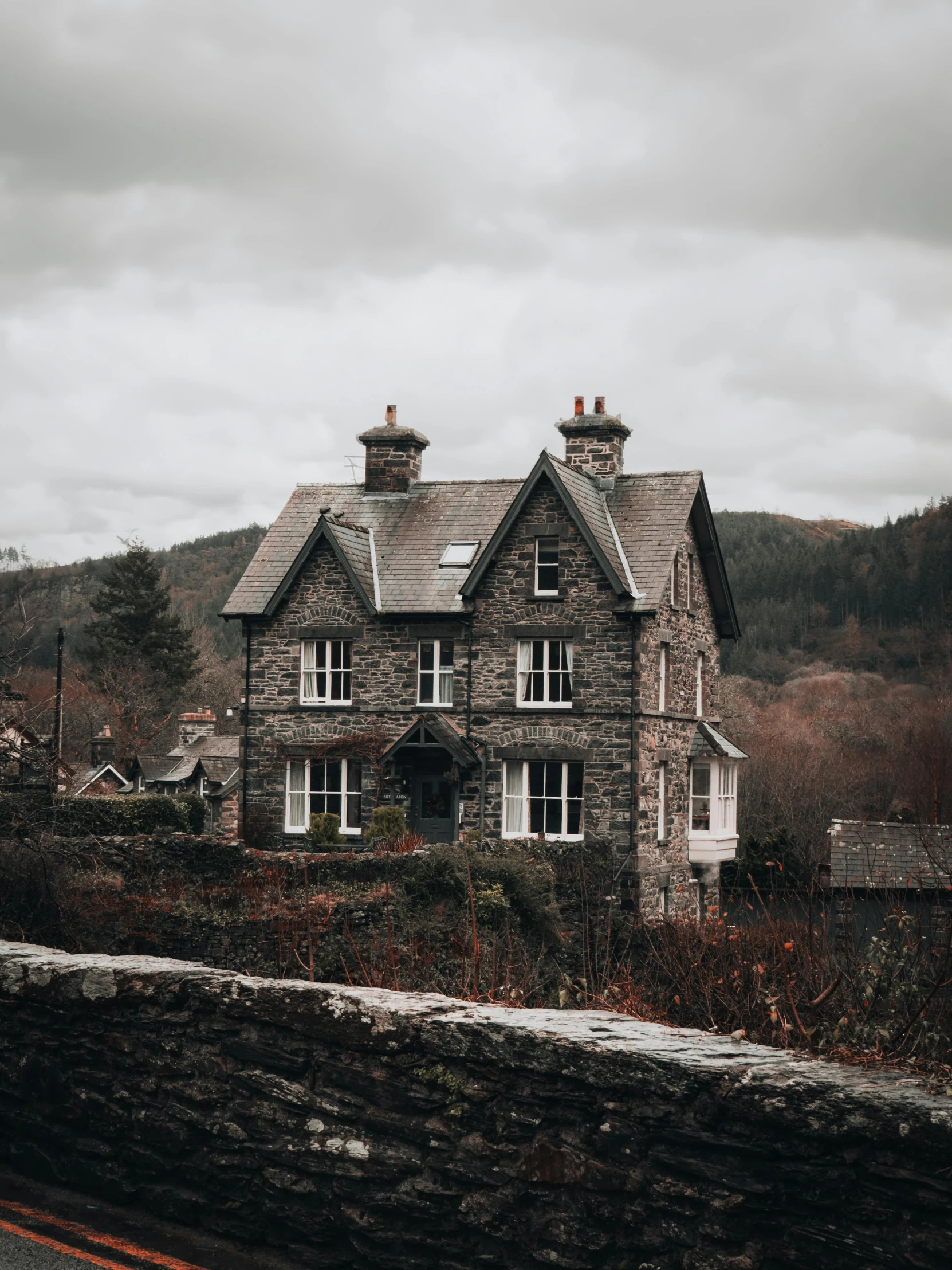 a stone and stucco house sits alone in the countryside