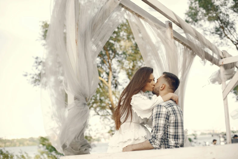 a man and a woman sitting next to each other in a gazebo