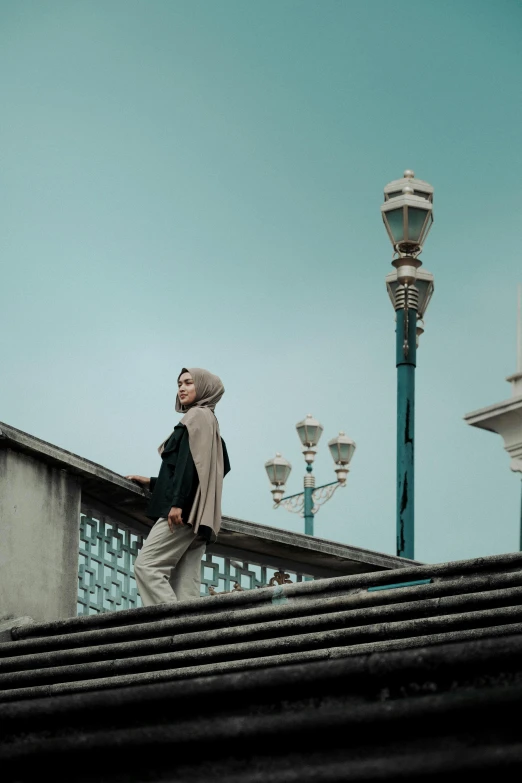 the man is walking up a railing towards a street light