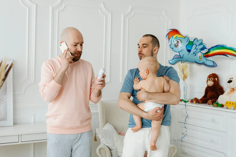 a man holding a baby and another man with an odd toothbrush