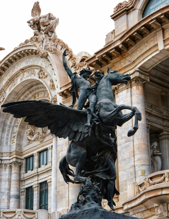 the statue has large wings and a man on it