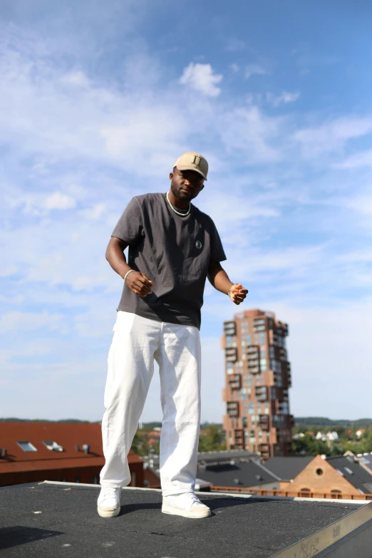 a man in a cap is standing on top of a building