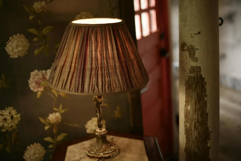 a lamp sitting on top of a table next to a window