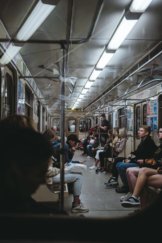 people sitting on a train in a subway during the day