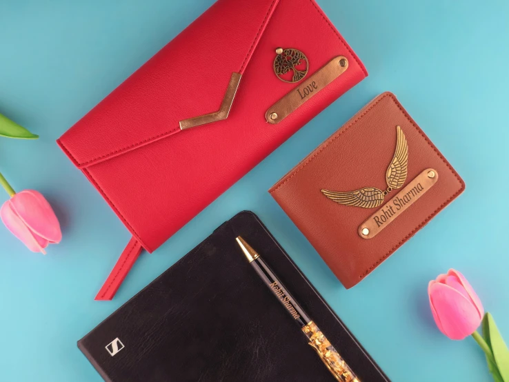 a desk top with flowers, notebook and two purses