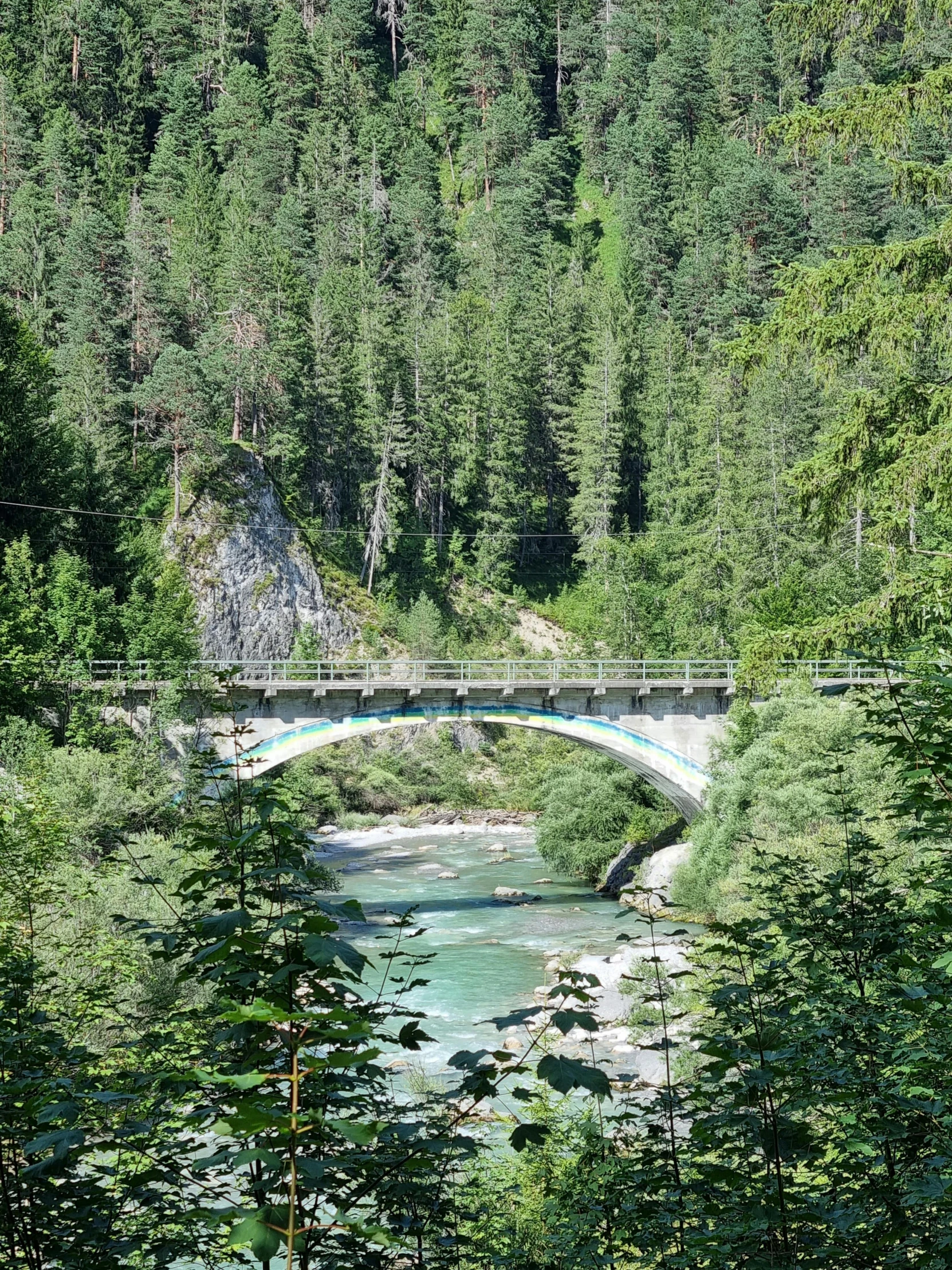 a bridge crosses over a river in the woods