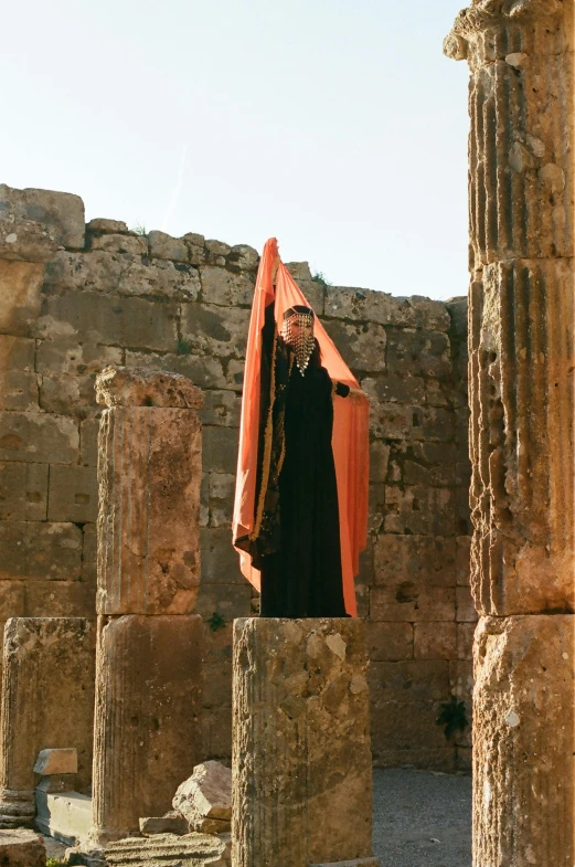 a woman with veil standing in front of a stone structure