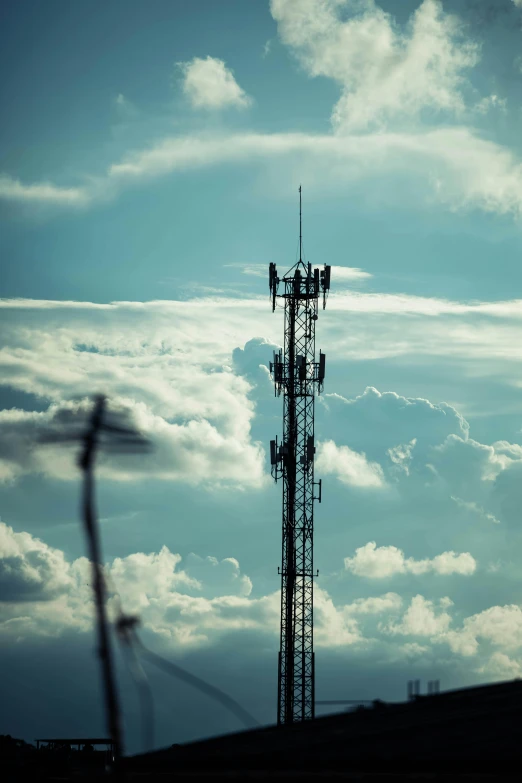 a tall tower stands surrounded by clouds