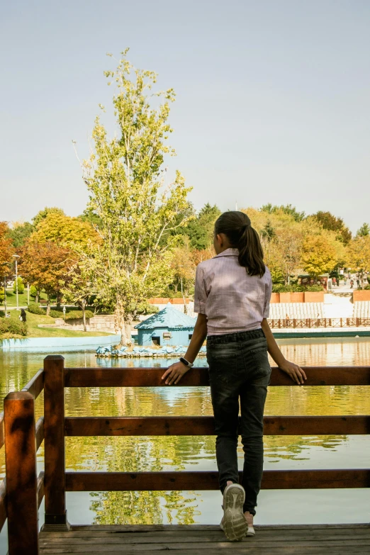 there is a woman that is standing on the dock looking at water