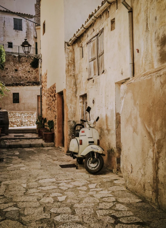 there is an old white scooter parked on the side of the street