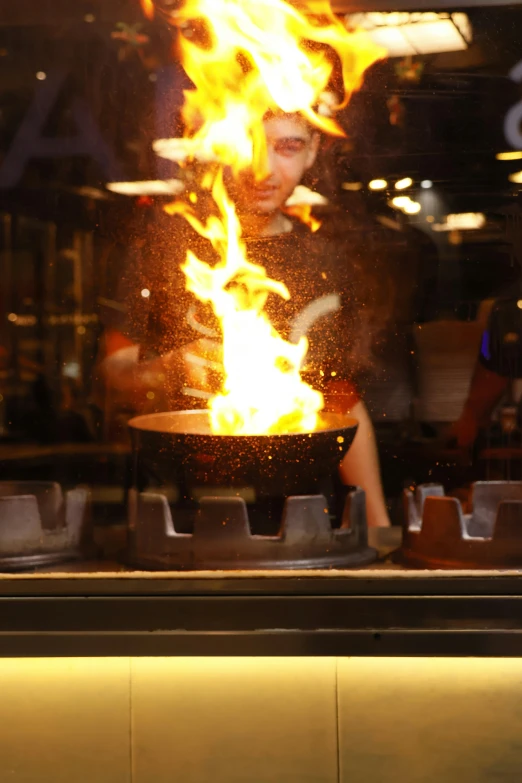 a man in front of a grill covered with flame