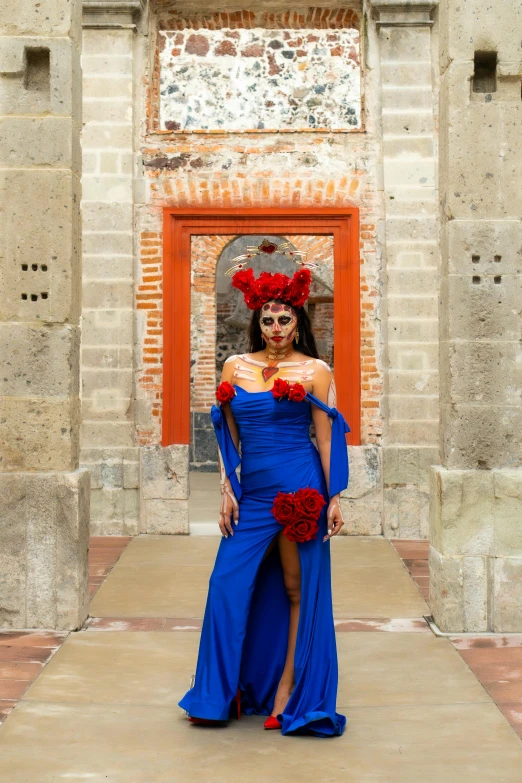 a beautiful woman dressed in red and blue stands in a courtyard