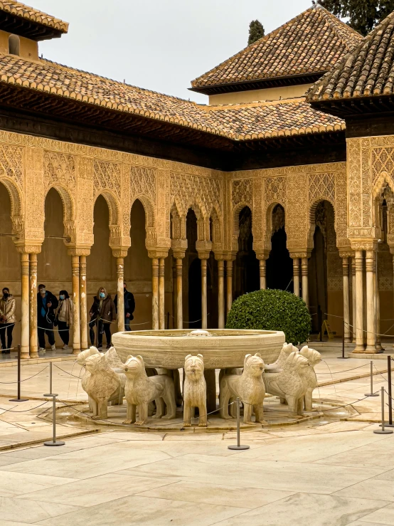 a large building with an outdoor courtyard with pillars and fountains