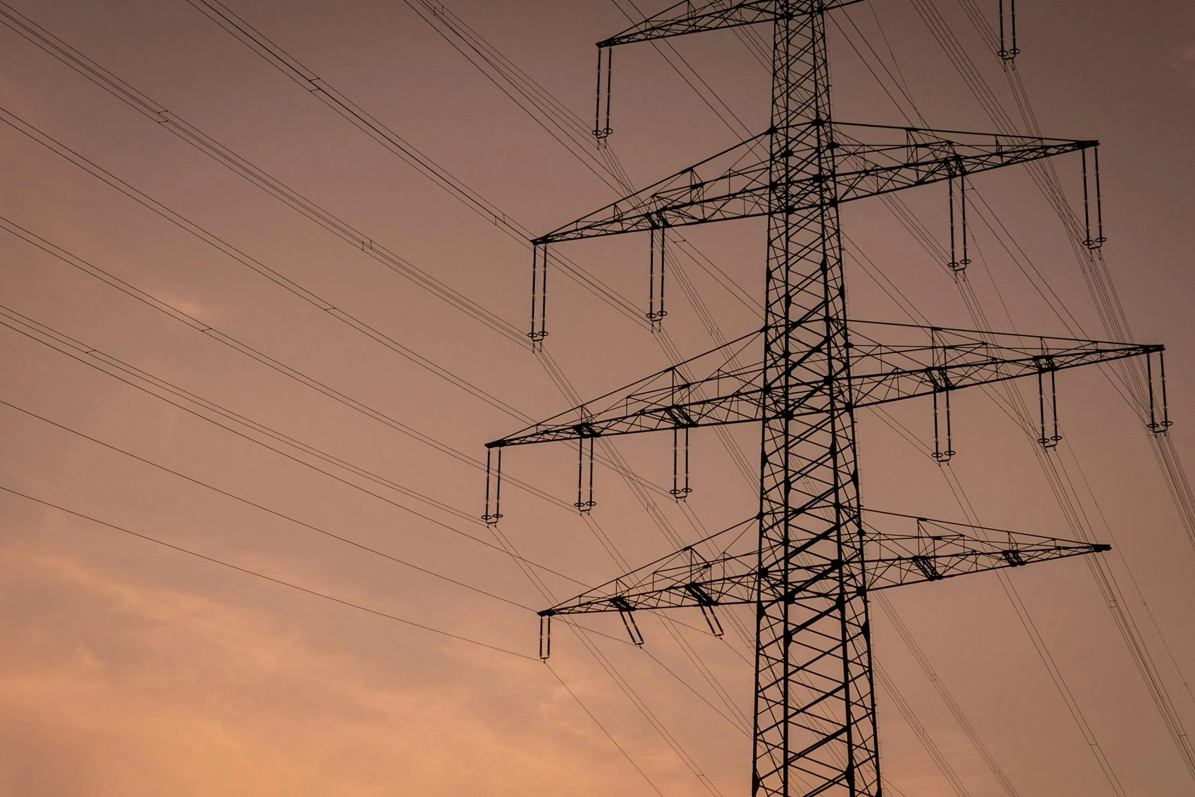 a tower with multiple lines in front of a sunset