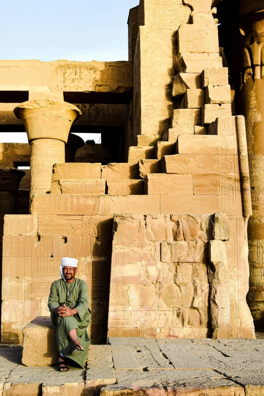 an old man is sitting by the side of the path