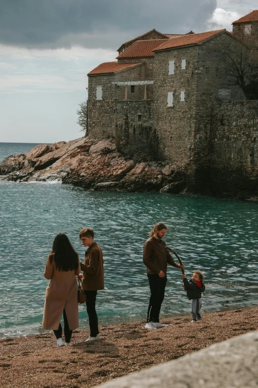 people standing near water watching some sort of building