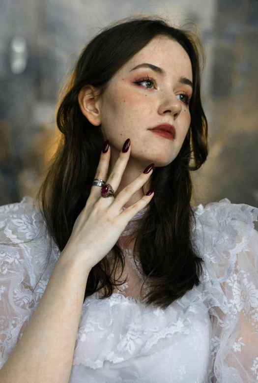 a young woman wearing a white dress posing for a picture