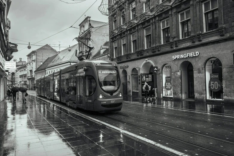 a black and white po of an old city street with a tram passing by