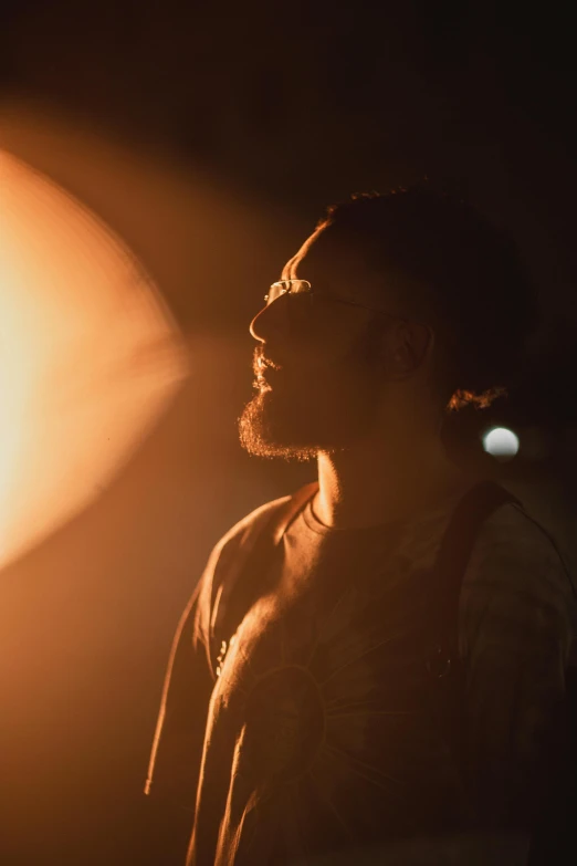 a man with a beard and  stands under a light