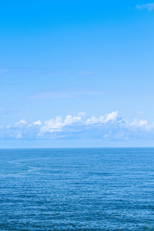 an ocean filled with lots of water under a cloudy blue sky